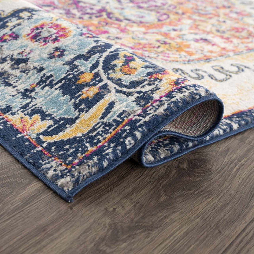 Close-up of the Tigrit Blue & Orange 2300 Area Rug showing its bohemian pattern, colors, and texture on a dark wood floor. Fold