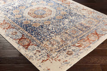 Close up of the Timnath Clearance Rug showing its blue, rust, and ivory traditional pattern. Corner