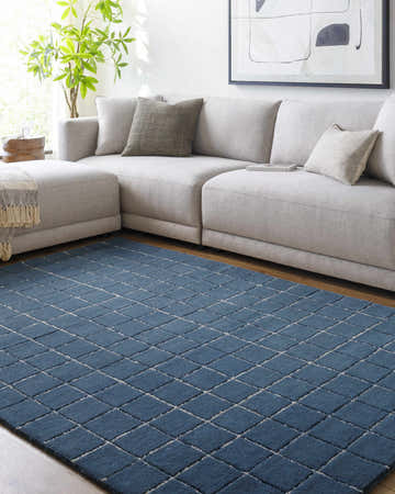 Living room scene with a gray sectional sofa and the Toshi Blue Area Rug with a diamond pattern. Roomscene-Rectangle