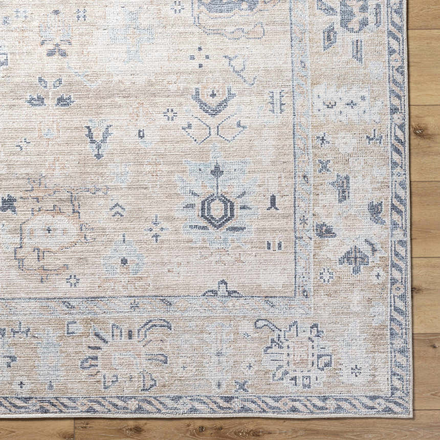 Close-up of the beige Toddy Area Rug with charcoal, mauve, and slate blue traditional pattern on a wood floor. Corner