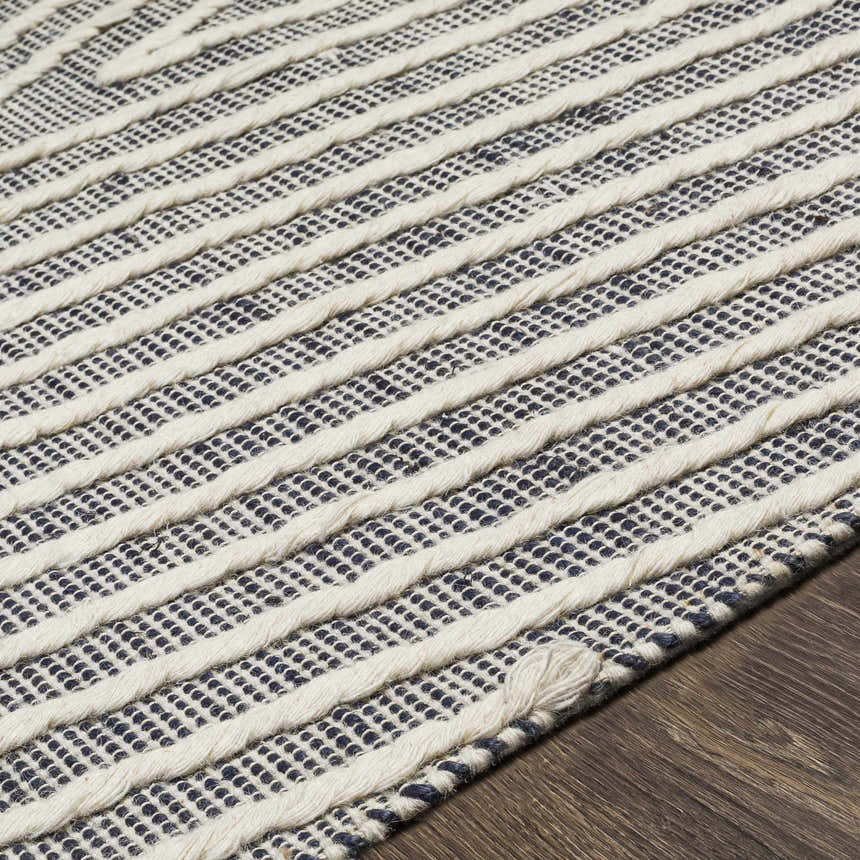 Close-up of the Tamayong Tasseled Jute&Wool Rug. Cream stripes accent the ink blue and jute weave. Hand woven texture detail. Texture