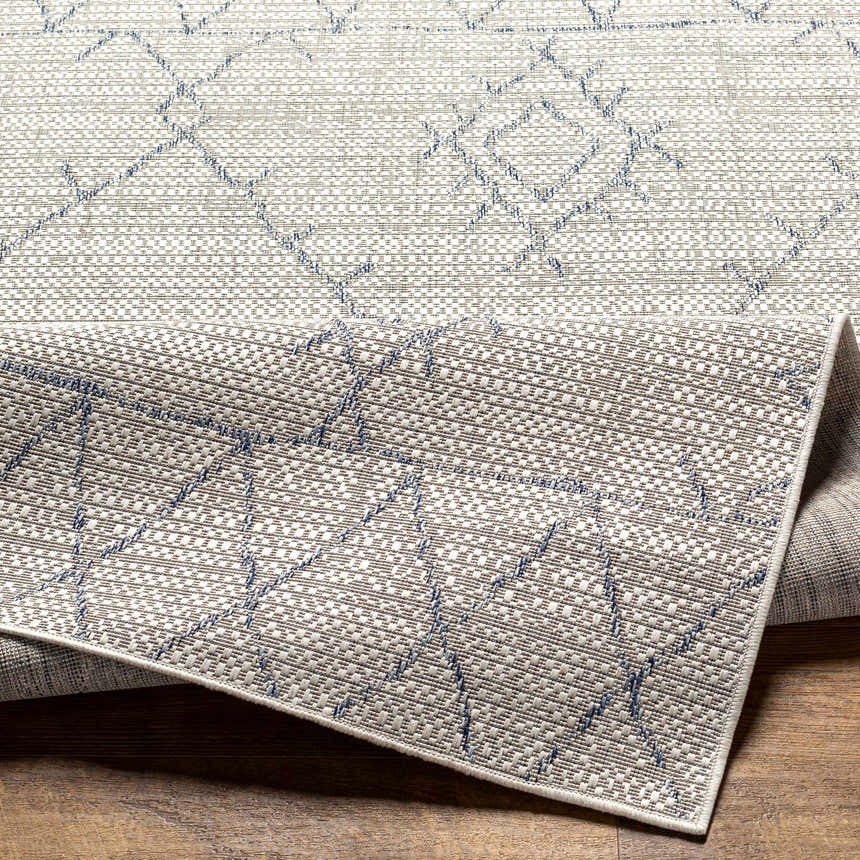 Close-up of the Marwood Gray&Blue Nordic Rug showing its geometric pattern, woven texture, and gray, blue, and off-white colors. Fold