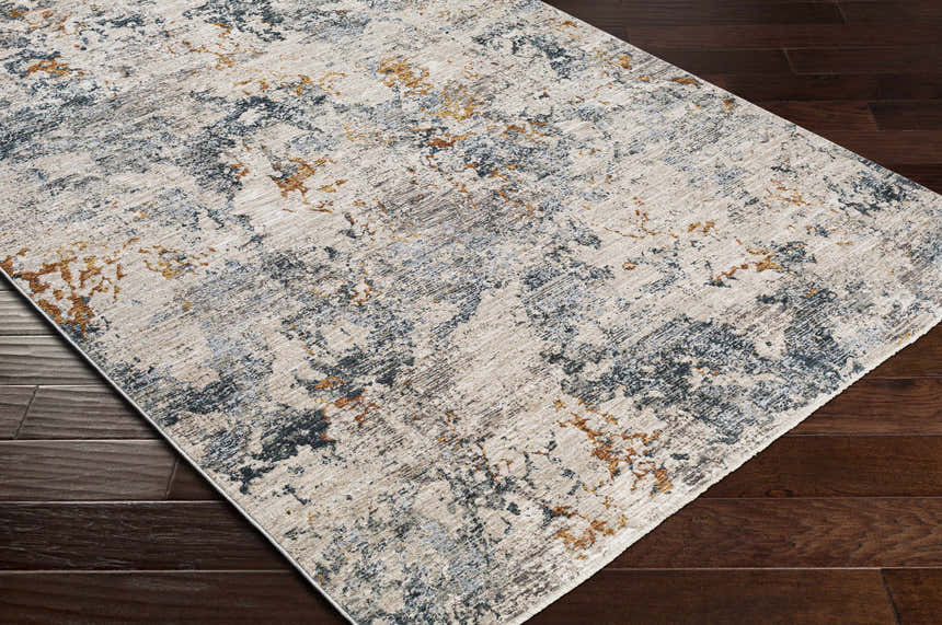 Close-up of the Tracyton Area Rug showing its cream, gray, light blue, and mustard abstract pattern on dark wood floors. Corner