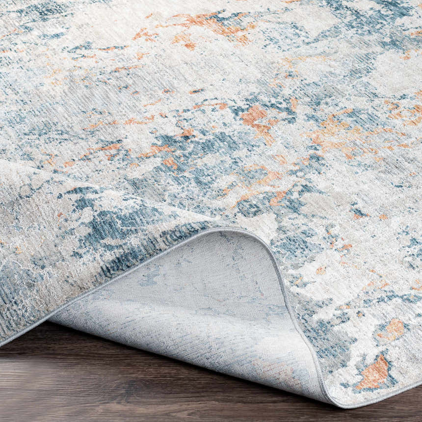 Close-up of the Tracyton Area Rug showing its abstract pattern in brick red, cream, dusty sage, gray, and light blue. Fold
