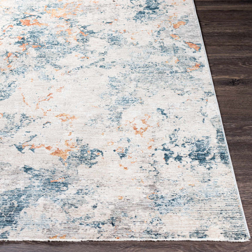 Close-up of the Tracyton Area Rug, featuring a contemporary abstract design in cream, light blue, and mustard on a dark wood floor. Front