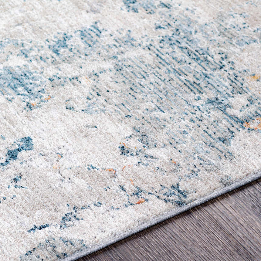 Close-up of the Tracyton Area Rug showing its cream base with light blue and mustard contemporary pattern. Texture