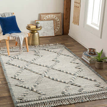 Styled room featuring the Tubao Area Rug. Bohemian decor with a chair, gold table, and wood floors. Roomscene-Rectangle