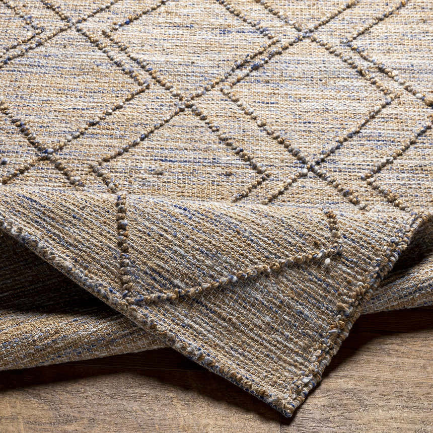Close-up of the hand woven Buse Beige & Blue Area Rug showing the jute texture and diamond pattern. Fold