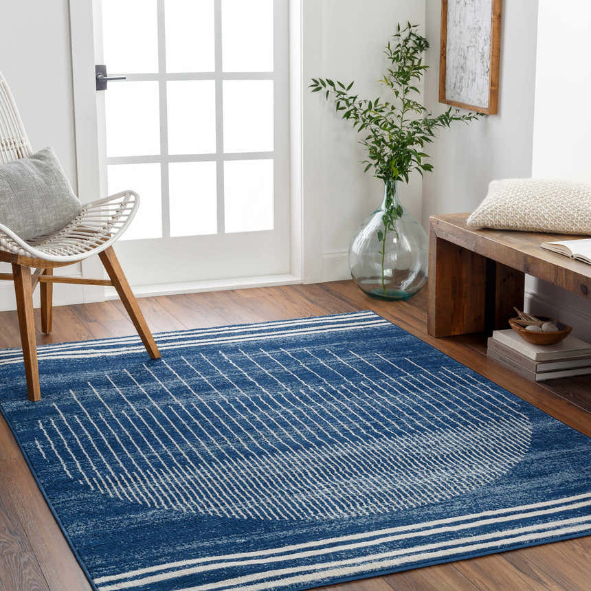 Entryway with blue Urja Area Rug, white chair, and wood bench. Modern geometric rug adds style to the space. Roomscene-Rectangle