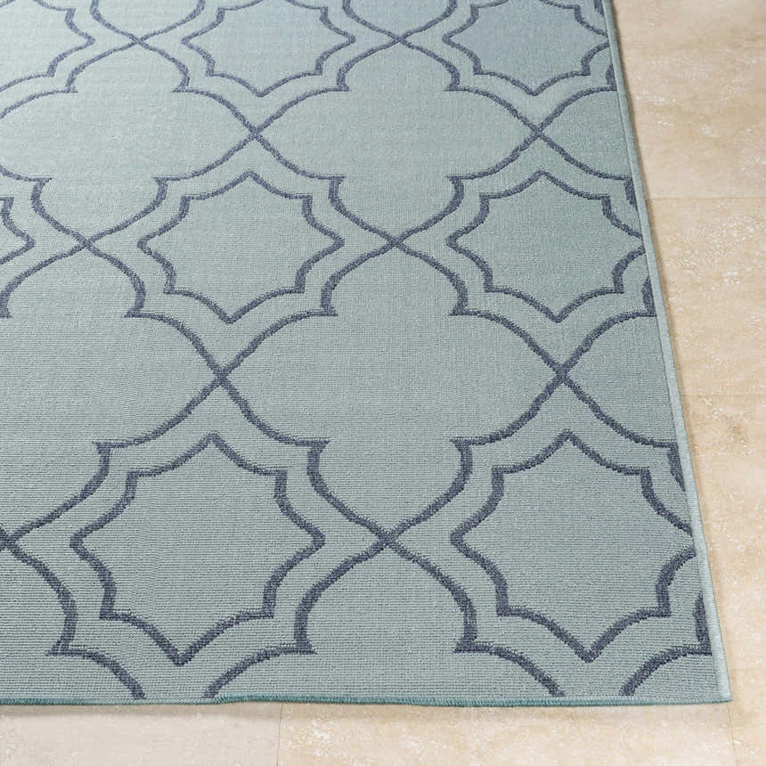 Close-up of the Ursa Area Rug. Pale blue rug with a navy geometric trellis pattern. Machine woven olefin rug. Front