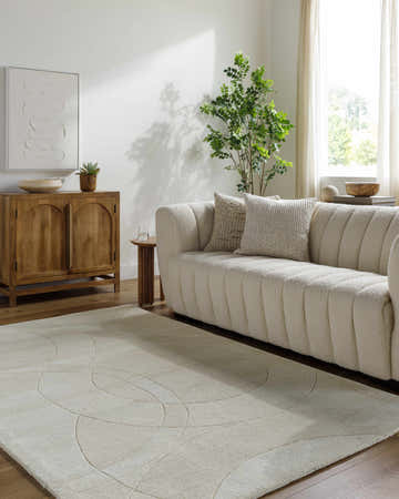 Living room scene with a light silver Ville Modern Wool Rug, textured sofa, and wood accents. Roomscene-Rectangle