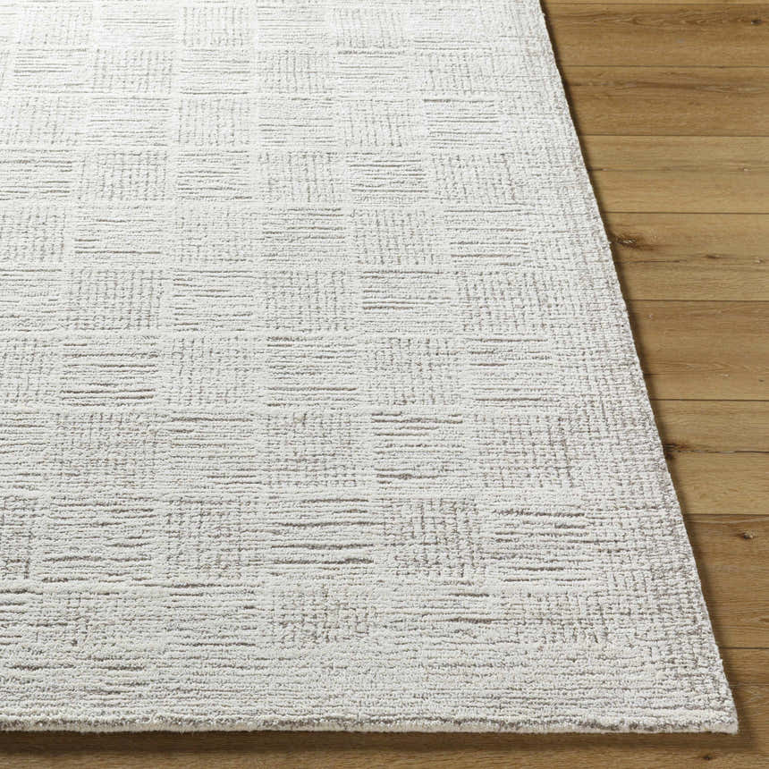 Close-up of the light silver Urian Area Rug with a subtle, contemporary grid pattern on a wood floor. Front