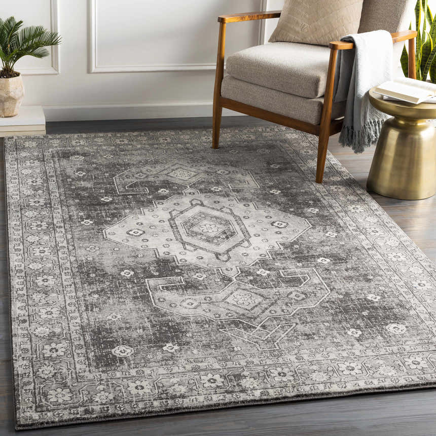 Living room scene with charcoal Vancouver Area Rug, gray chair, and gold side table. Roomscene-Rectangle