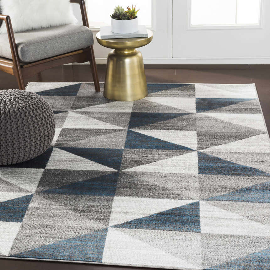 Living room scene with blue and gray Volant Area Rug, modern chair, and gold accent table. Roomscene-Rectangle