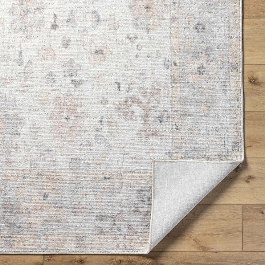 Close-up of the Valko Area Rug showing its farmhouse style, dusty pink, gray, and light brown traditional pattern. Fold