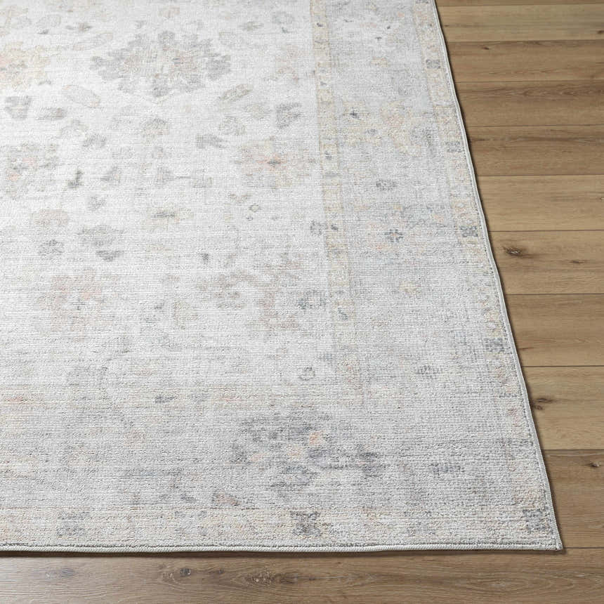 Close-up of the Valko Area Rug showing its traditional, dusty pink, gray, and light brown pattern and woven texture. Front