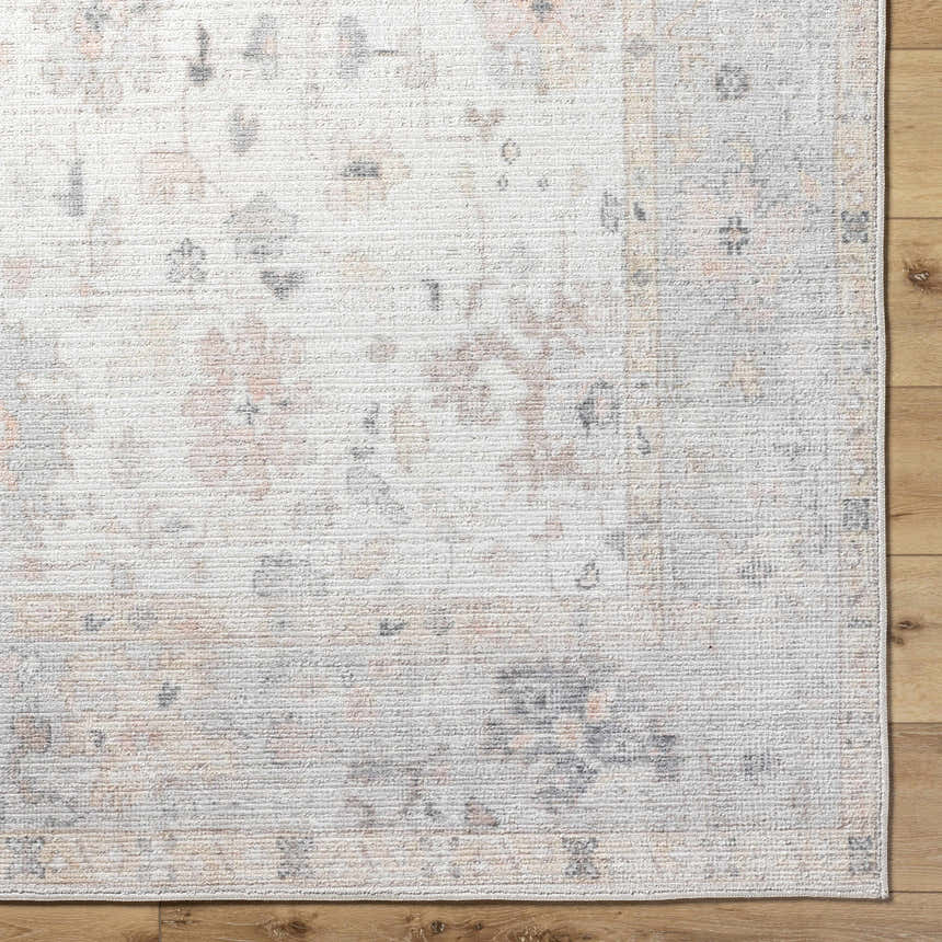 Close-up of the Valko Area Rug featuring a traditional design in dusty pink, gray, and light brown on a textured polyester weave. Corner