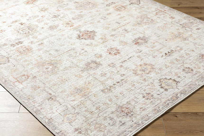 Close-up of the Verna Area Rug showing its traditional pattern, dark brown, dusty coral, gray, and ivory colors. Corner