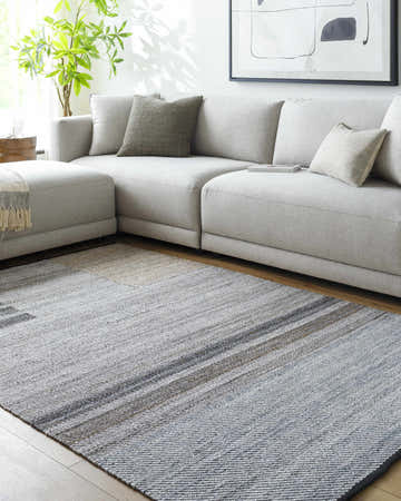 Living room with gray sectional and Velda Area Rug in charcoal, gray, sage, and slate blue. Southwestern style. Roomscene-Rectangle