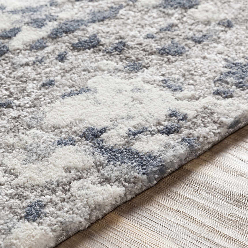 Close-up of the Walhonding Area Rug showing its denim, ivory, and gray contemporary pattern and soft, textured pile. Texture