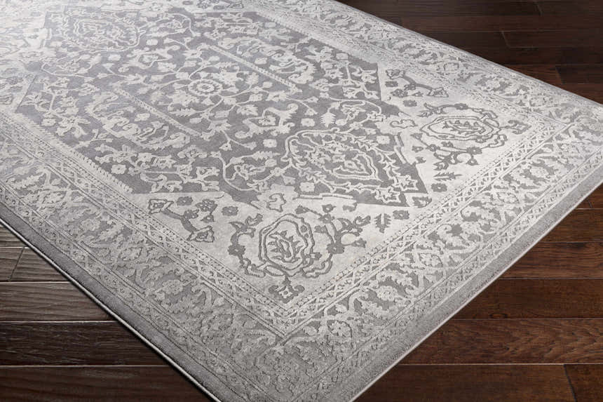 Close-up of the Watford Updated Traditional Tibetan Rug. Gray and ivory floral pattern on a charcoal background. Corner