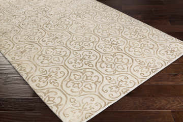 Close-up of the hand-loomed Wauseon Area Rug. Ivory rug with an olive floral pattern on dark wood floors. Corner
