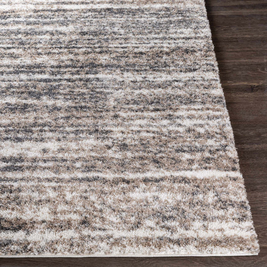 Close-up of the Weddin Striped Plush Area Rug showing charcoal, cream, gray, and tan stripes and soft, shaggy texture. Front