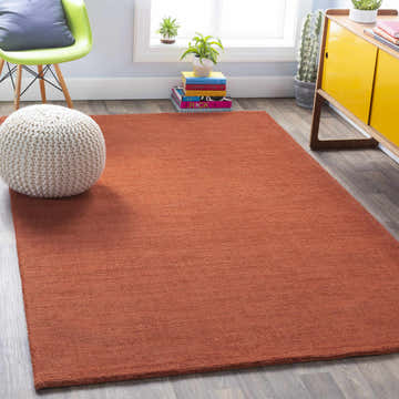 Bright room scene with a solid orange Brockton wool rug, lime chair, and yellow cabinet. Roomscene-Rectangle