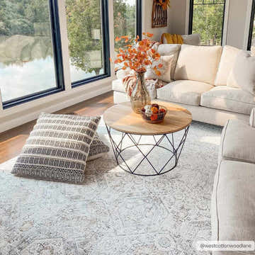 Living room scene featuring a neutral sofa and the beige Parkerfield Area Rug with a vintage, traditional pattern. Roomscene-Rectangle