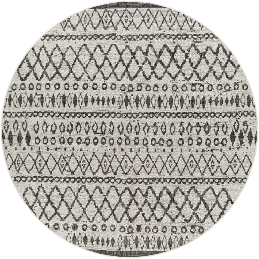 Close-up of the round Westside Outdoor Area Rug. Black and white geometric, bohemian pattern. Machine woven polypropylene rug. Design-Round-710
