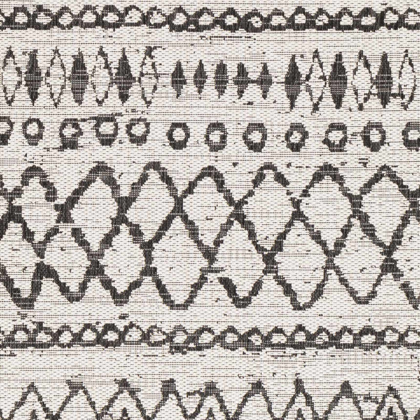 Close-up of the Westside Outdoor Area Rug showing its black and white bohemian-inspired geometric pattern and woven texture. Swatch