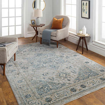 Living room scene with a Whangamata Thick Luxe Boutique Rug in light gray and teal, styled with neutral furniture and wood floors. Roomscene-Rectangle