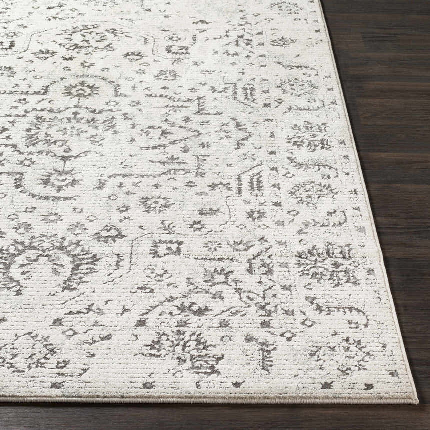 Close up of the Willowbrook Area Rug, a vintage style rug in charcoal and gray on dark wood floor. Front