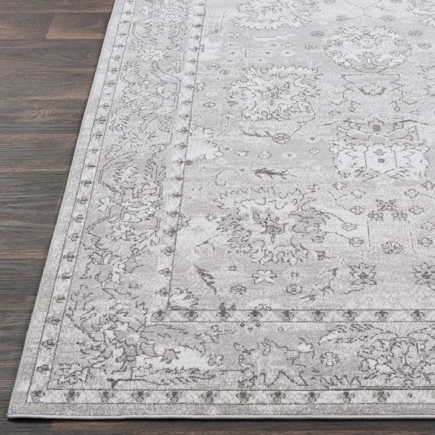 Close up of the Winstonville Clearance Rug. Light gray rug with a traditional floral pattern on dark wood floors. Front