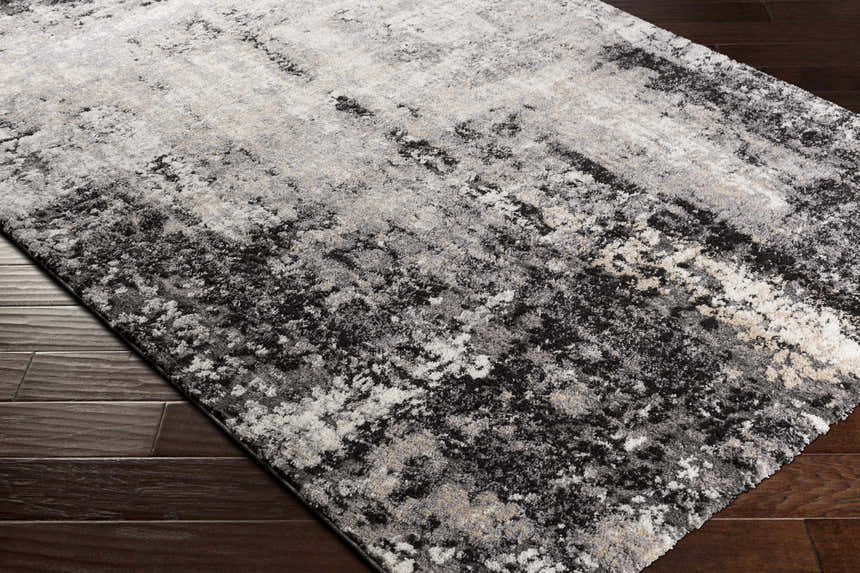 Close-up of the Witchford Abstract Charcoal Thick Rug showing its black, gray, ivory, and tan abstract pattern and plush texture. Corner