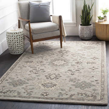 Living room scene with a Willimantic Beige Thick Wool Rug, gray chair, side table, and plants. Neutral tones create a calming mood. Roomscene-Rectangle