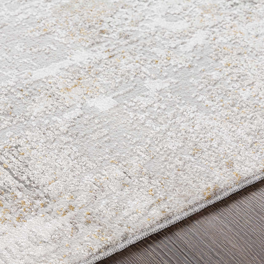 Close-up of the textured Windale Luxe Area Rug. Light gray rug with subtle geometric pattern and hints of mustard. Texture