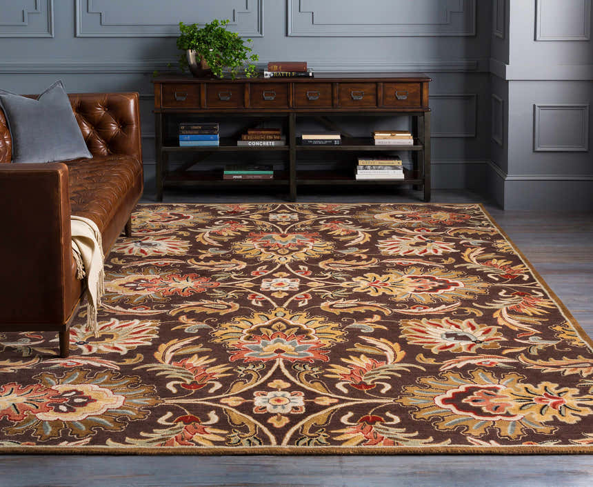 Living room scene with a brown leather sofa and the Chesterton 1028 brown wool rug with floral oriental design. Roomscene-Rectangle