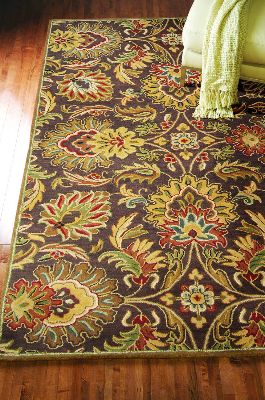 Close-up of the Chesterton 1028 hand-tufted brown wool rug with a traditional floral pattern in brown, gold, red, and green. Styleshot