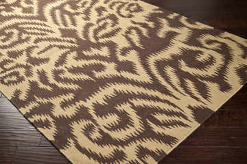 Close-up of the Waterlooville Area Carpet. Dark brown and mustard wool rug with a contemporary, abstract pattern. Corner