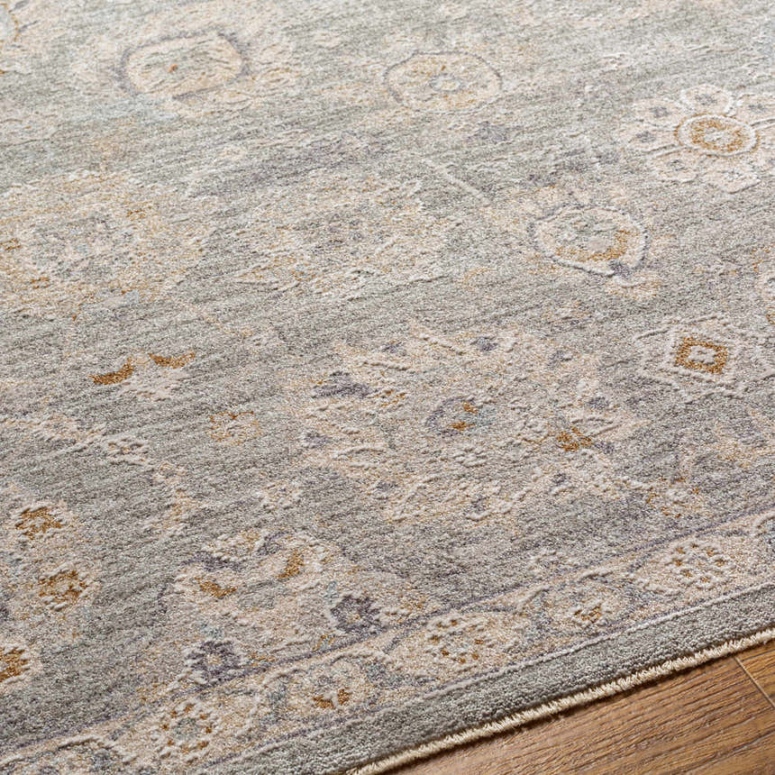 Close-up of the Wurtulla Thick Luxe Statement Rug. Features a traditional, vintage pattern in dusty sage, beige, and brown tones. Texture