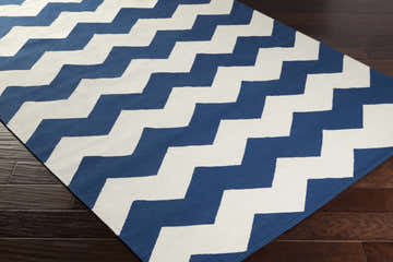 Close-up of the Wykoff Area Rug, ivory and navy zig zag pattern on dark wood floor. Contemporary style. Corner