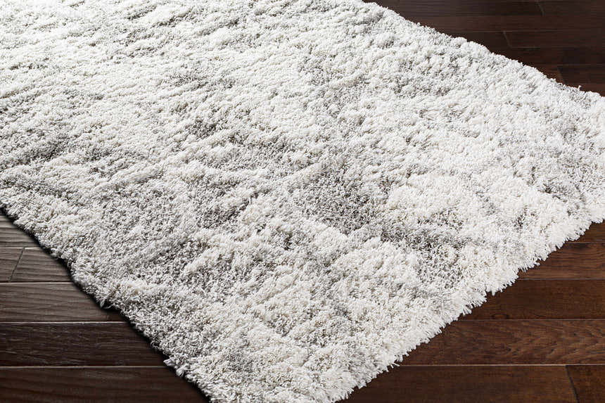 Close-up of the plush Wynant Gray Tones Rug showing its soft texture and light gray, medium gray, and off-white colors. Corner