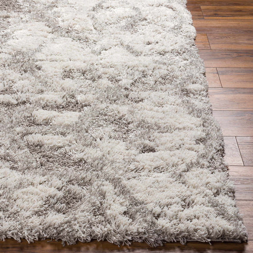 Close-up of the plush Wynant Gray Tones Rug. Shag rug with light gray, medium gray, and off-white tones. Contemporary style. Front