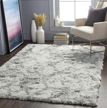 Living room scene with a gray Wynant Gray Tones Plush Rug, beige chair, and modern decor. Roomscene-Rectangle