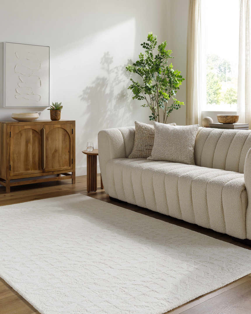 Living room scene with a light silver Xenon Area Rug, textured sofa, wood cabinet, and natural light. Roomscene-Rectangle