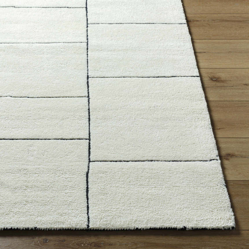 Close-up of the hand-tufted Xylia Ivory Area Rug showing its pearl color, wool texture, and contemporary geometric pattern. Front