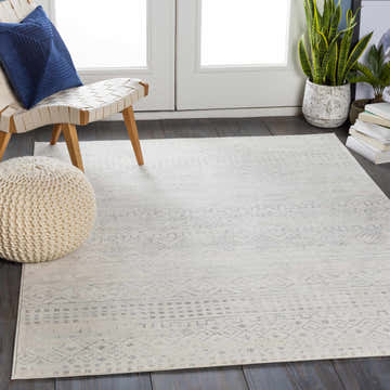 Entryway scene with a gray and white Yamanto Area Rug, chair, and pouf. Roomscene-Rectangle