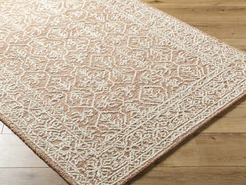 Close-up of the hand-tufted Yadid Brown Wool Area Rug showing its traditional tan and pearl geometric pattern and textured weave. Corner