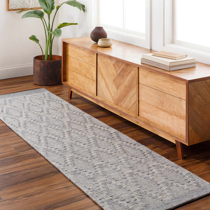 Hallway scene with light gray Yank Area Rug runner, wood console table, plant, and hardwood floors. Roomscene-Runner